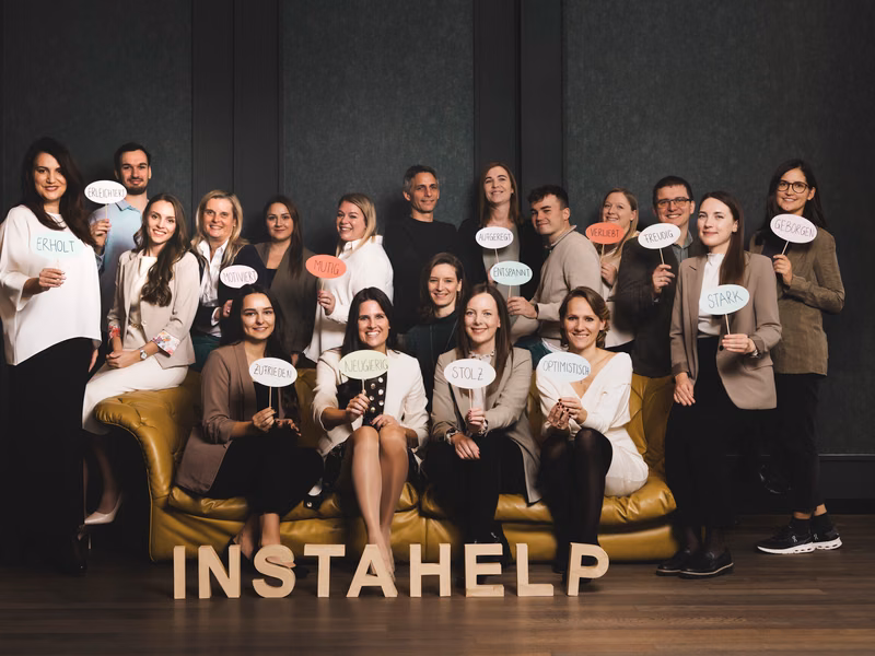 Un groupe de personnes posant pour une photo d'&eacute;quipe, chacune tenant un panneau avec des attributs positifs.